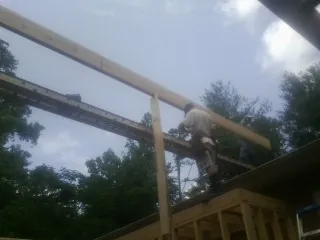 Carpenter setting a ridge beam over a new addition frame — Ice Dam Removal by Roofing Brothers in Wesley