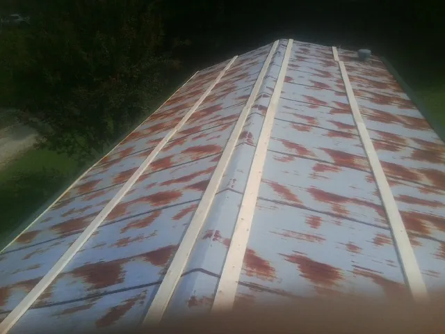 Rusted metal roof panels with new wood purlins before replacement — Storm Damage Roof Repair in Wesley by Roofing Brothers