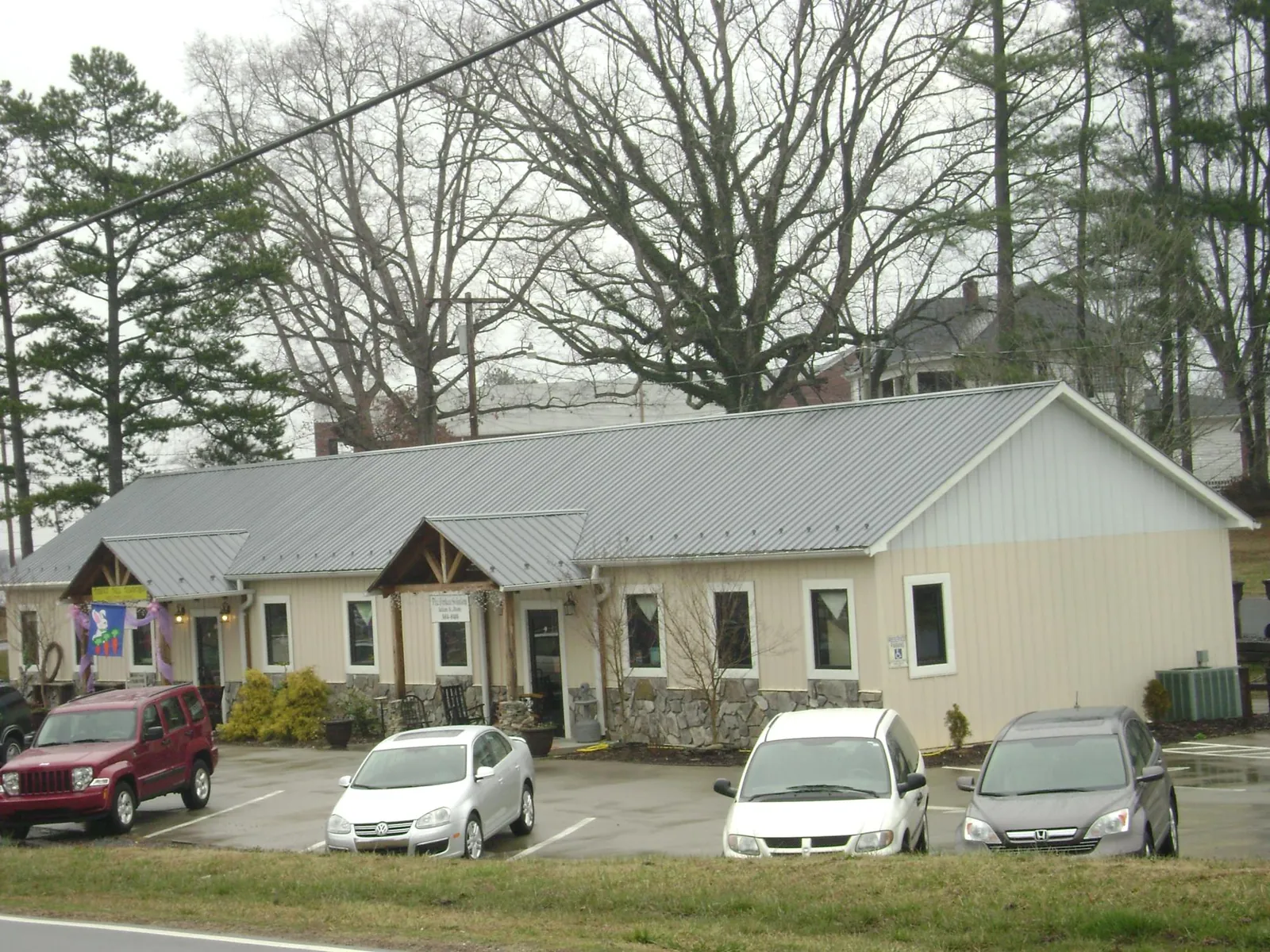 Gray metal roof with timber entry brackets on a small commercial building in Wesley