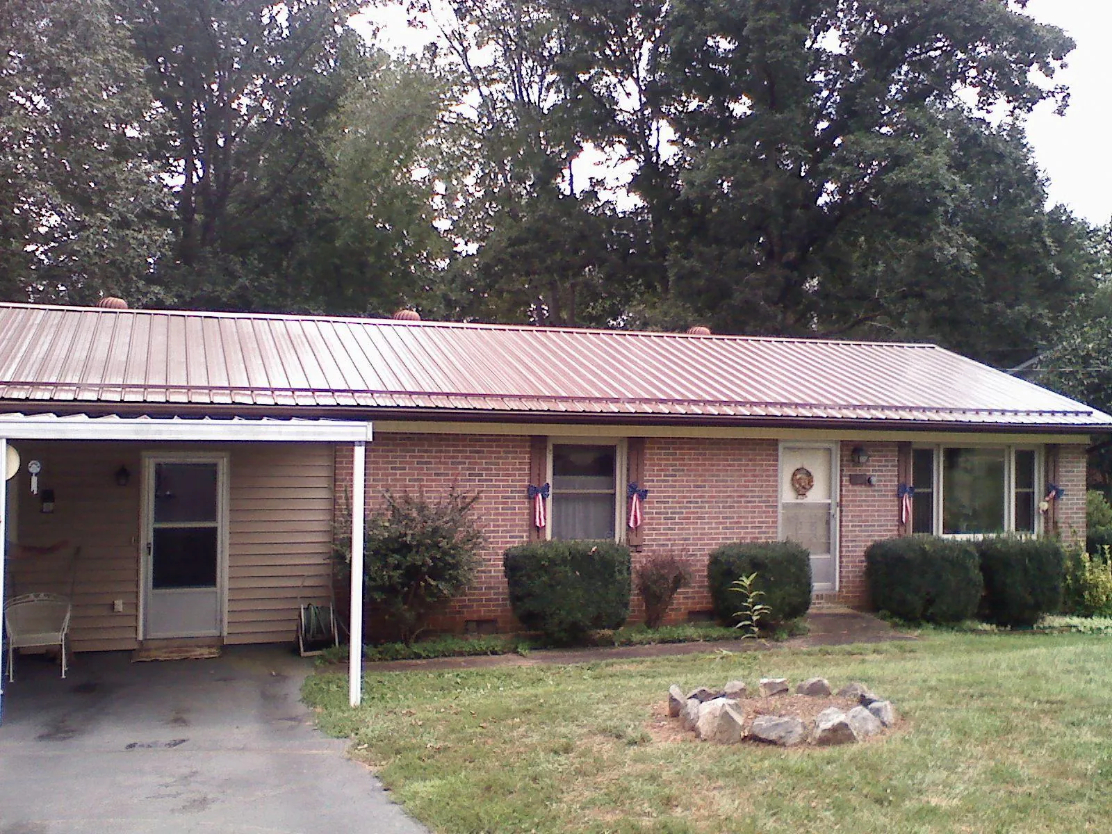 Bronze metal roof and carport on a brick ranch home — Roof Repair work by our crew in Wesley